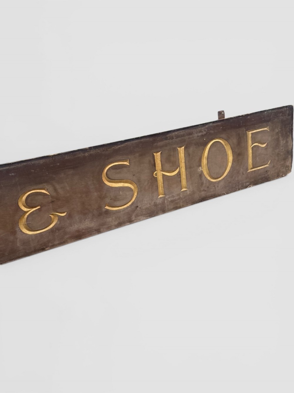 A long rectangular dark wooden sign with incised serif letters spelling DEPARTMENT gilded in gold leaf. View IV