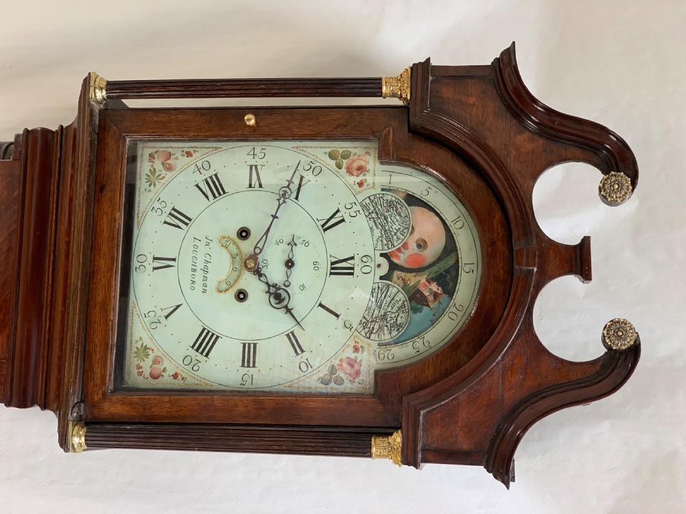 An antique dark wood longcase clock featuring a swan-neck pediment, fluted columns, and a painted moonphase dial signed by John Chapman Loughborough. View IV