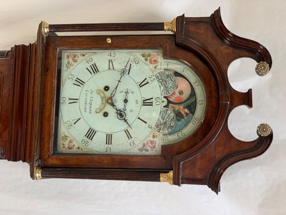 An antique dark wood longcase clock featuring a swan-neck pediment, fluted columns, and a painted moonphase dial signed by John Chapman Loughborough. View V