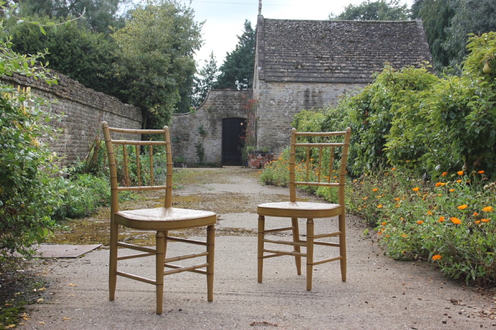 A set of four matching faux bamboo side chairs featuring turned timber frames and woven cane seats. View II