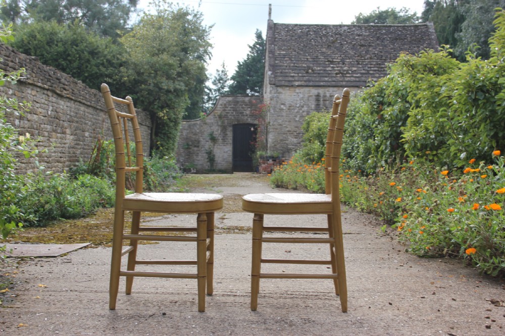 A set of four matching faux bamboo side chairs featuring turned timber frames and woven cane seats. View III