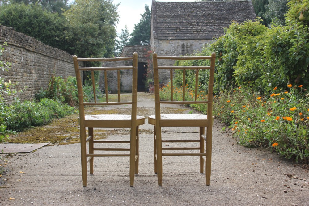 A set of four matching faux bamboo side chairs featuring turned timber frames and woven cane seats. View IV