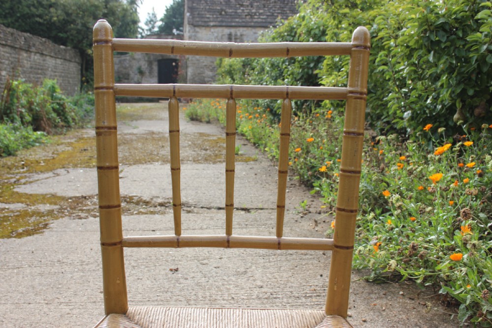 A set of four matching faux bamboo side chairs featuring turned timber frames and woven cane seats. View V