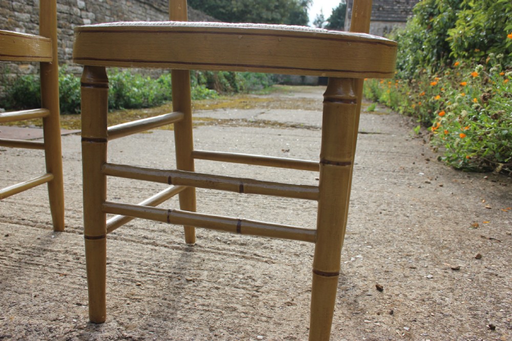 A set of four matching faux bamboo side chairs featuring turned timber frames and woven cane seats. View VI