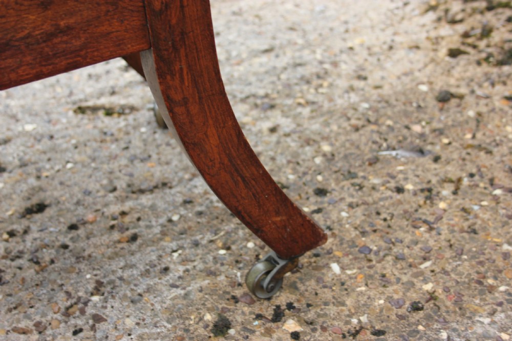 A 19th-century Victorian turned mahogany slipper chair with a spindle back and patterned upholstered seat resting on turned legs with brass castors. View III