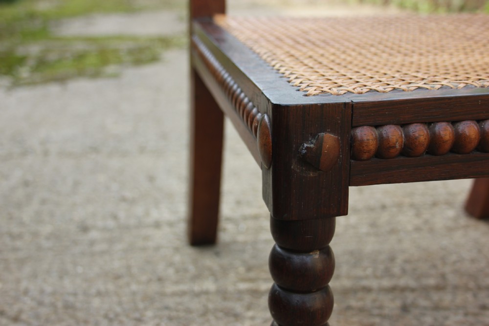 A 19th-century dark rosewood side chair featuring lathe-turned bobbin legs and backrest spindles with a woven cane seat. View IV