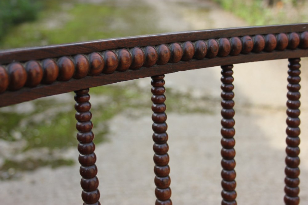 A 19th-century dark rosewood side chair featuring lathe-turned bobbin legs and backrest spindles with a woven cane seat. View VII
