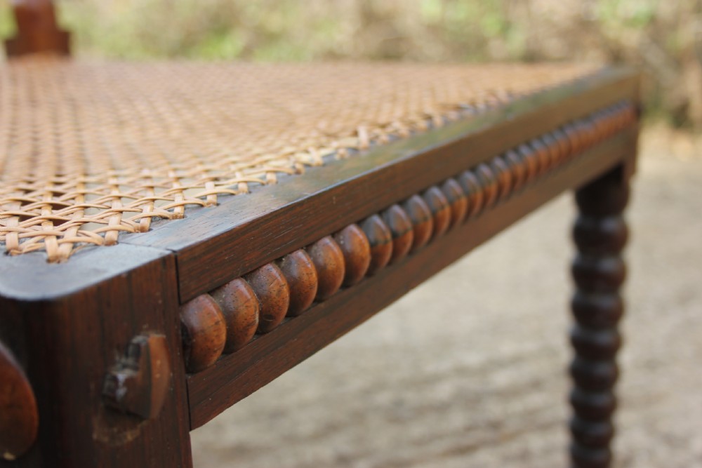 A 19th-century dark rosewood side chair featuring lathe-turned bobbin legs and backrest spindles with a woven cane seat. View VIII