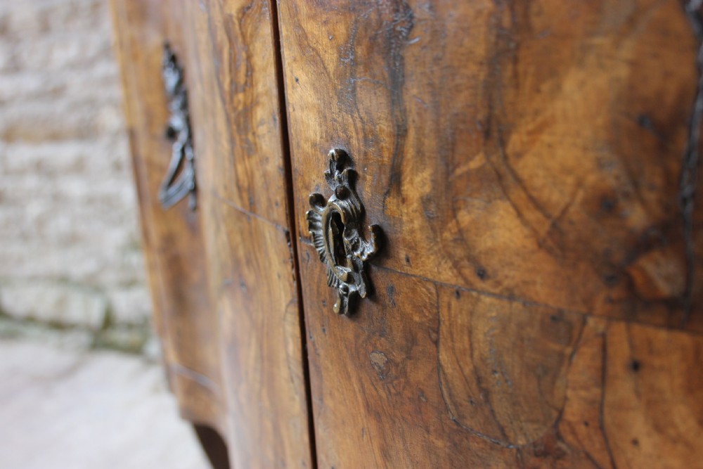 An eighteenth-century Italian walnut commode featuring a serpentine curved front, two panel doors, cabriole legs, and dark metal handles. View III