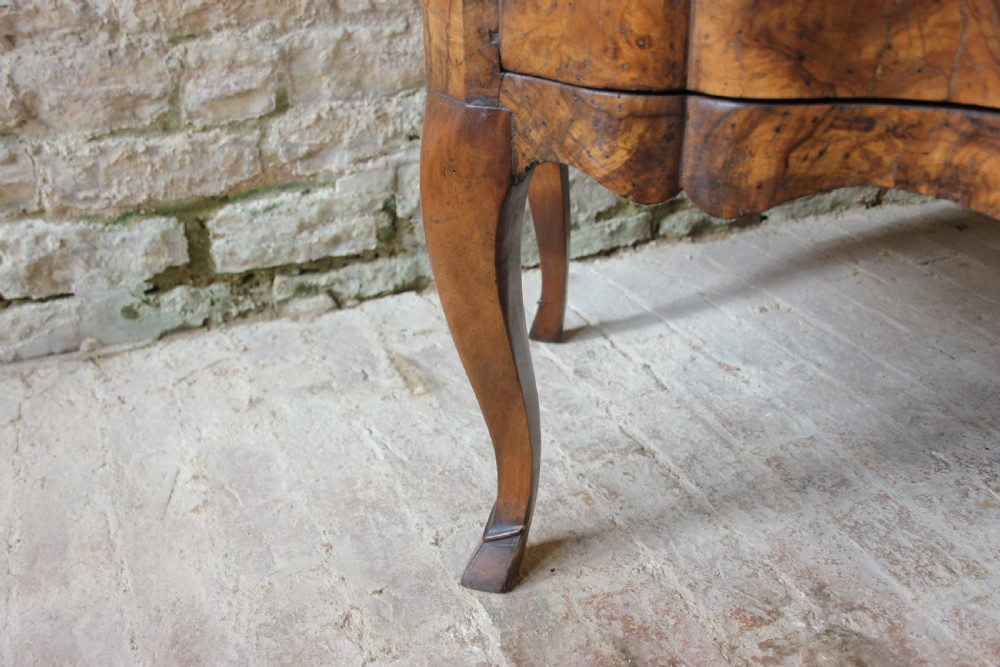 An eighteenth-century Italian walnut commode featuring a serpentine curved front, two panel doors, cabriole legs, and dark metal handles. View X