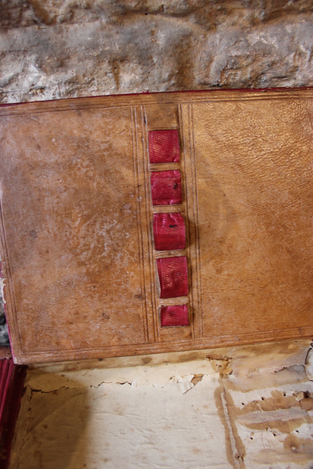 A 19th-century patinated brown leather attache case featuring a top handle, fold-over flap, brass clasp, and decorative embossed detailing around a central brass keyhole. View V