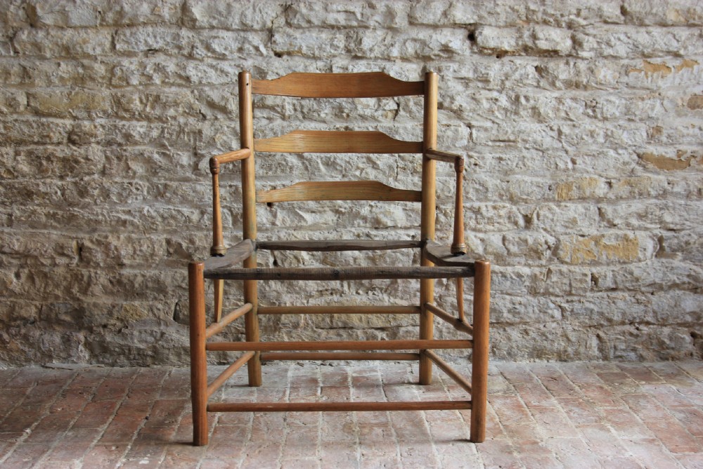 A low-slung Scandinavian light wood nursing chair featuring horizontal ladderback splats, turned arm supports, and multiple stretchers. View II