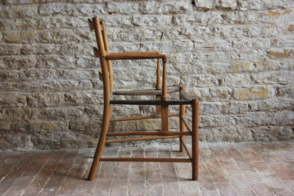 A low-slung Scandinavian light wood nursing chair featuring horizontal ladderback splats, turned arm supports, and multiple stretchers. View IV