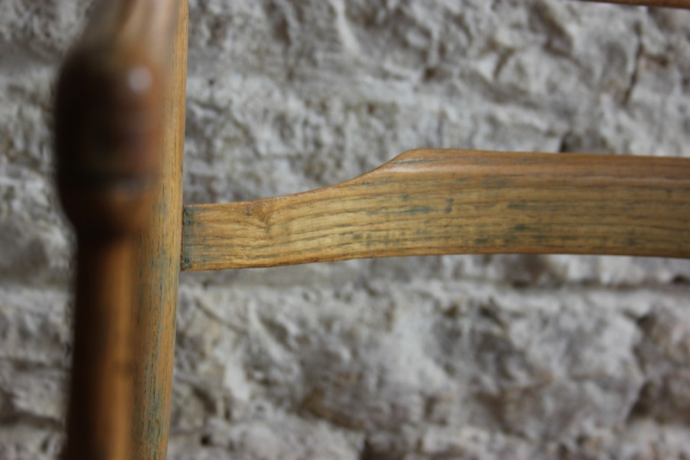 A low-slung Scandinavian light wood nursing chair featuring horizontal ladderback splats, turned arm supports, and multiple stretchers. View V