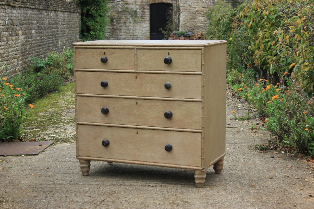 An early nineteenth-century painted chest of drawers featuring faux bamboo moulding, dark turned wood knobs, and a two-over-three drawer configuration.