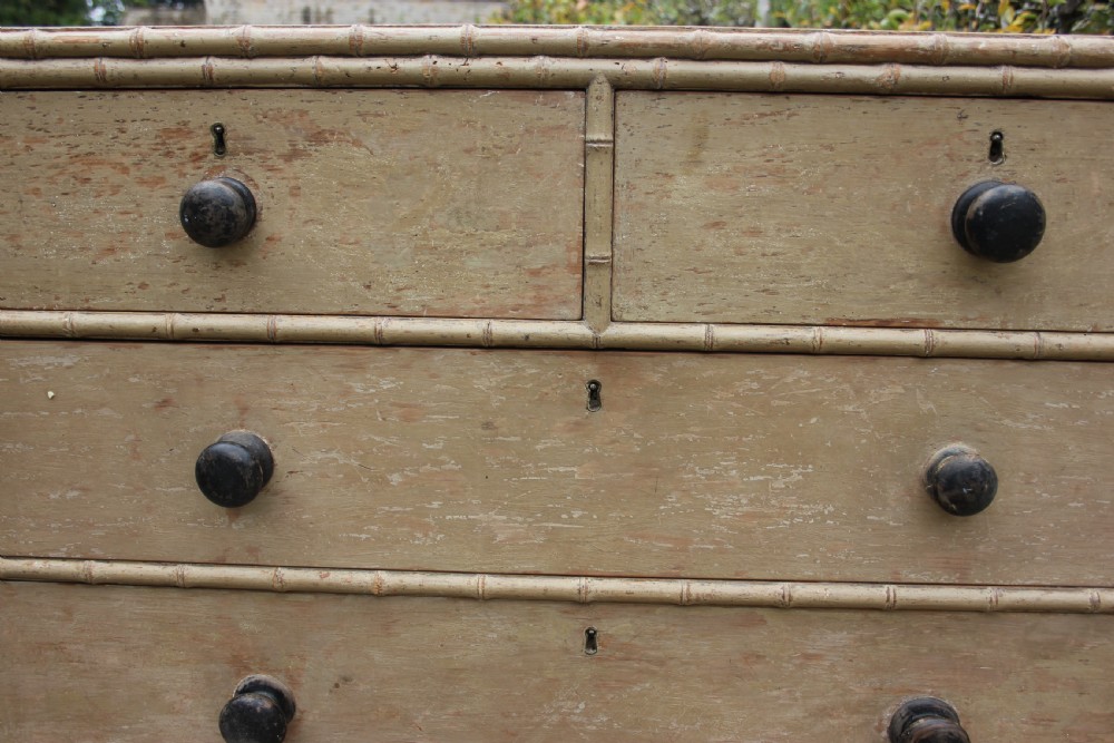 An early nineteenth-century painted chest of drawers featuring faux bamboo moulding, dark turned wood knobs, and a two-over-three drawer configuration. View VI
