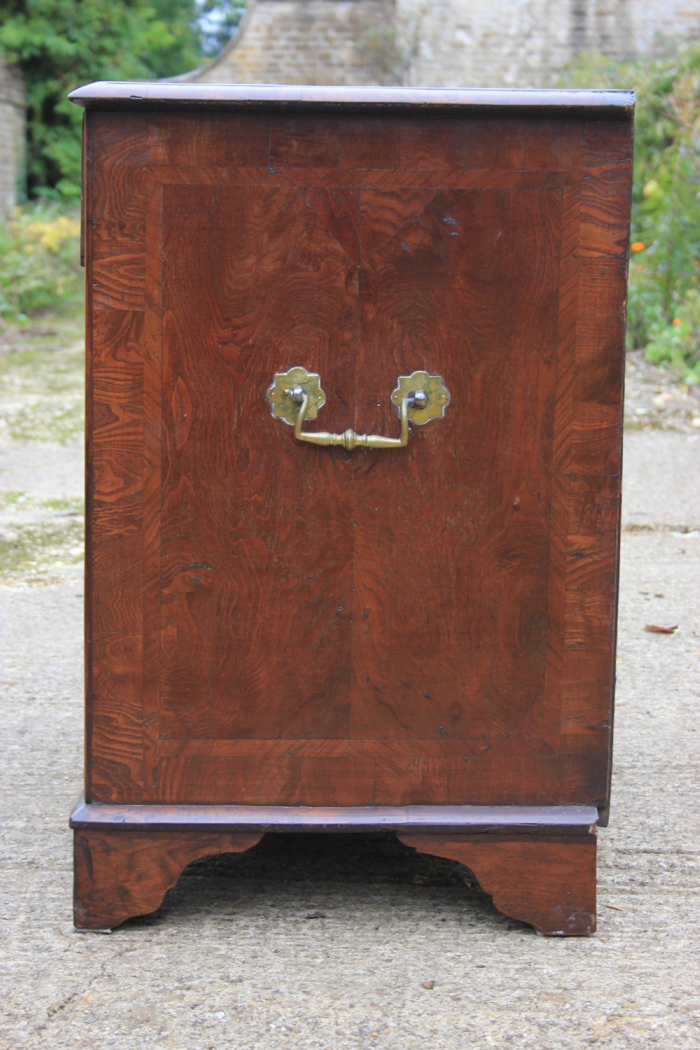 An 18th-century Dutch elm chest of drawers featuring four shaped serpentine drawers with brass drop handles and side carrying handles. View II