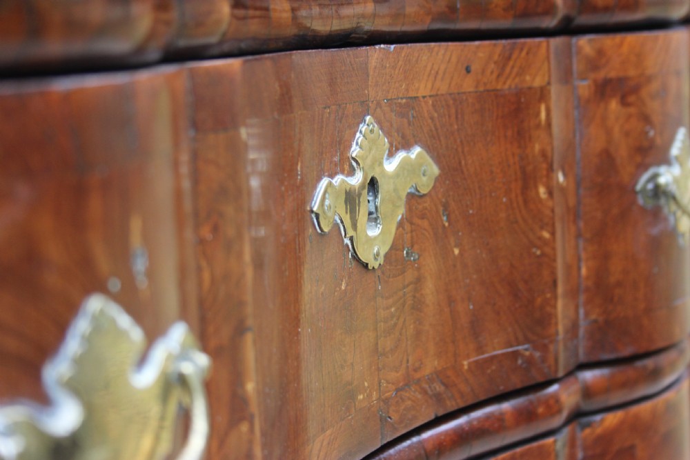 An 18th-century Dutch elm chest of drawers featuring four shaped serpentine drawers with brass drop handles and side carrying handles. View III