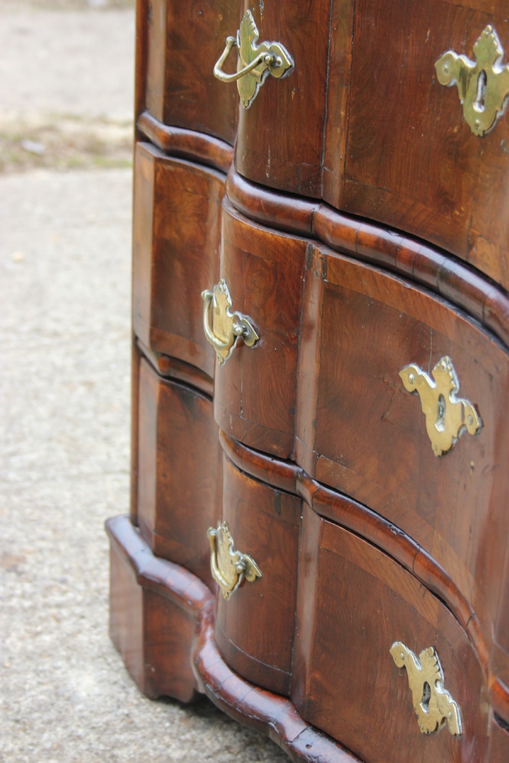 An 18th-century Dutch elm chest of drawers featuring four shaped serpentine drawers with brass drop handles and side carrying handles. View VIII