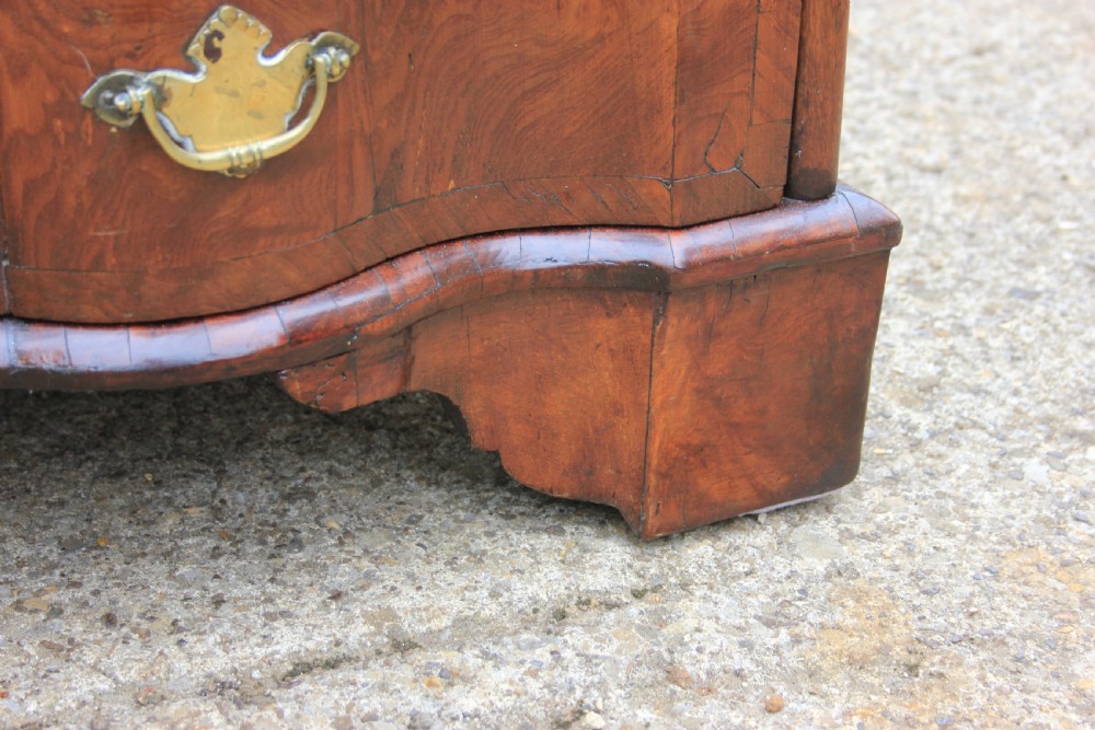 An 18th-century Dutch elm chest of drawers featuring four shaped serpentine drawers with brass drop handles and side carrying handles. View XI