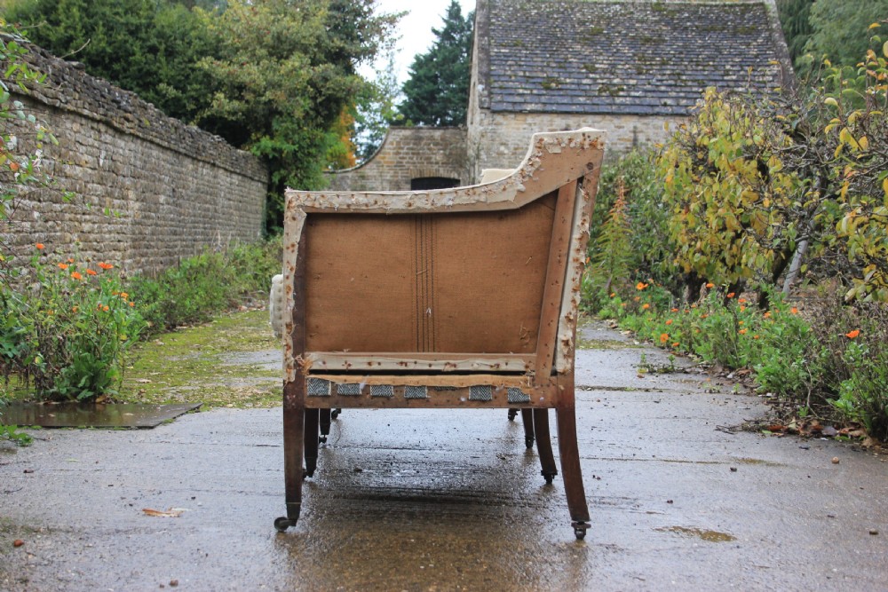 An early 19th-century sofa frame with calico lining, cylindrical bolster cushions, and square mahogany legs on brass castors. View III
