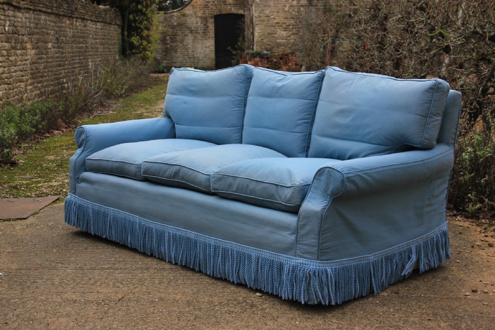 A three-seater English country house sofa upholstered in light blue fabric featuring a deep bullion fringe skirt. View II