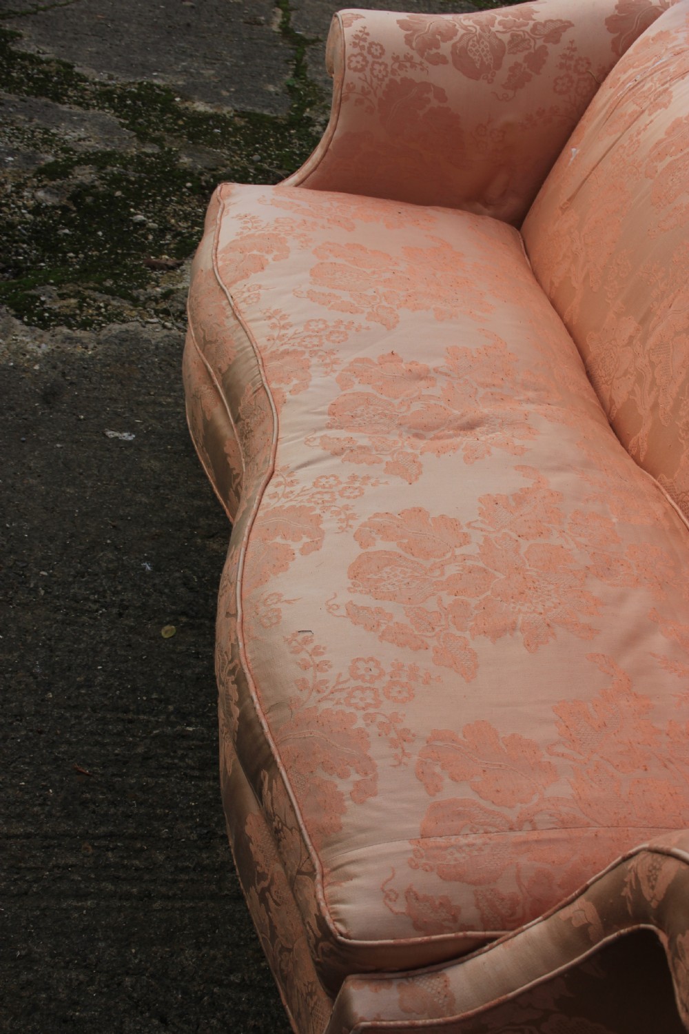 A peach damask upholstered camel back sofa featuring a serpentine seat cushion, out-scrolled arms, and square mahogany legs connected by stretchers. View VI