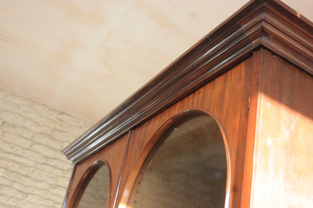 A 19th-century mahogany glazed bookcase featuring two arched glass doors, internal wooden shelving, and two lower drawers with turned wooden knobs. View II