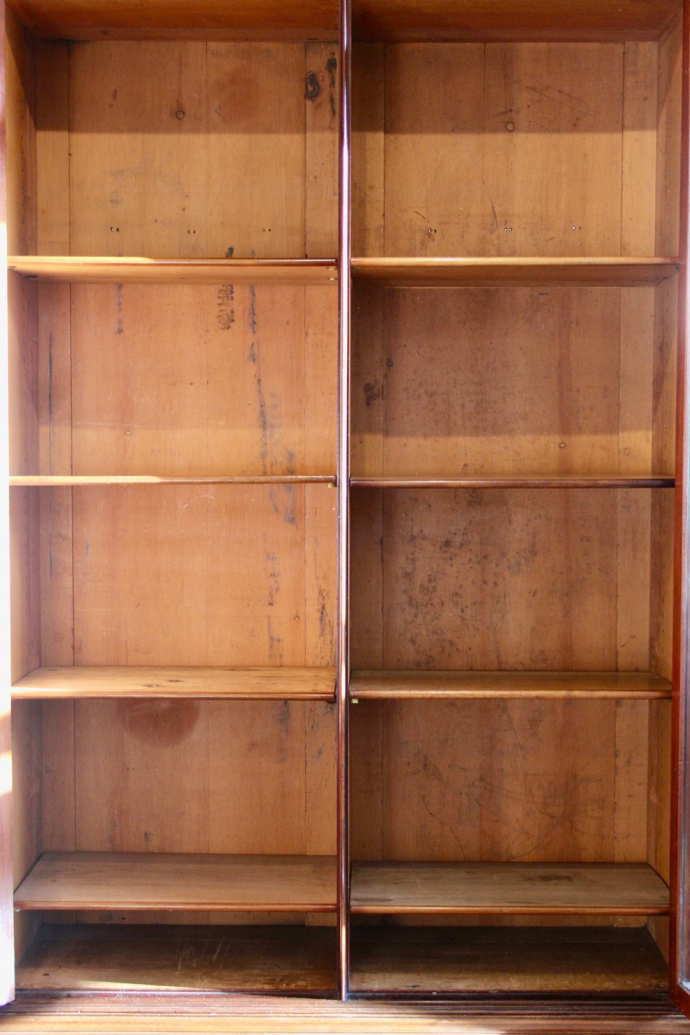 A 19th-century mahogany glazed bookcase featuring two arched glass doors, internal wooden shelving, and two lower drawers with turned wooden knobs. View III