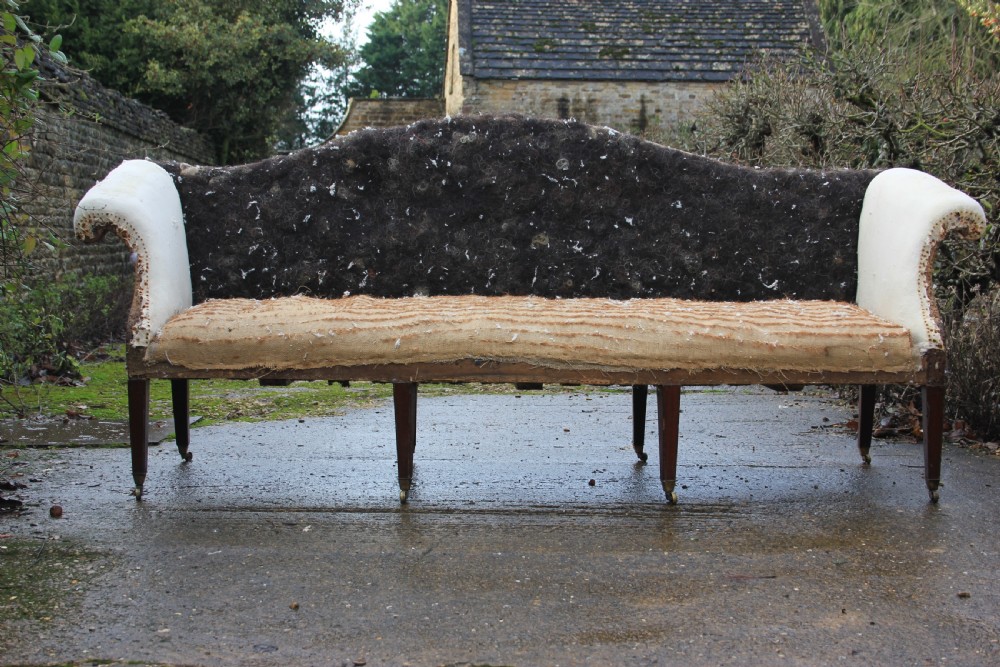 An 18th-century camel back sofa featuring a serpentine front rail, scrolled arms, and tapered mahogany legs. View IV