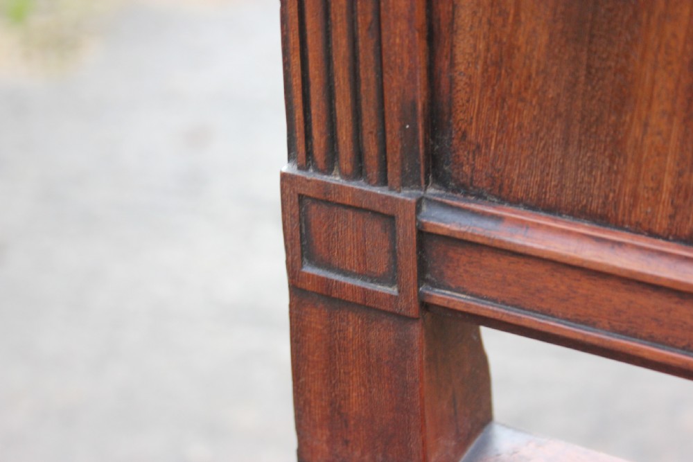 A pair of mahogany hall chairs featuring carved backrests with central circular mouldings, solid timber seats, and fluted turned front legs. View VI
