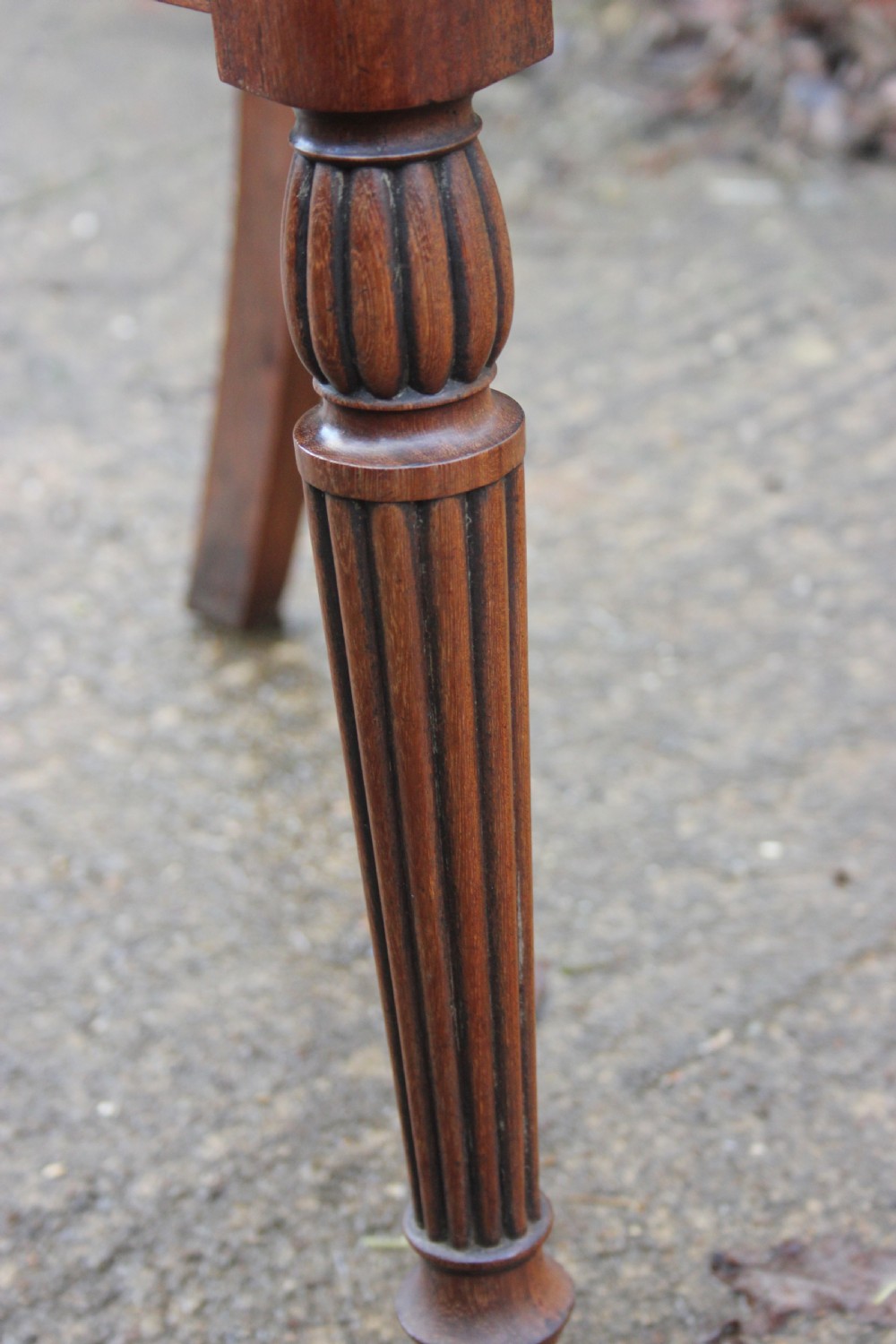 A pair of mahogany hall chairs featuring carved backrests with central circular mouldings, solid timber seats, and fluted turned front legs. View IX