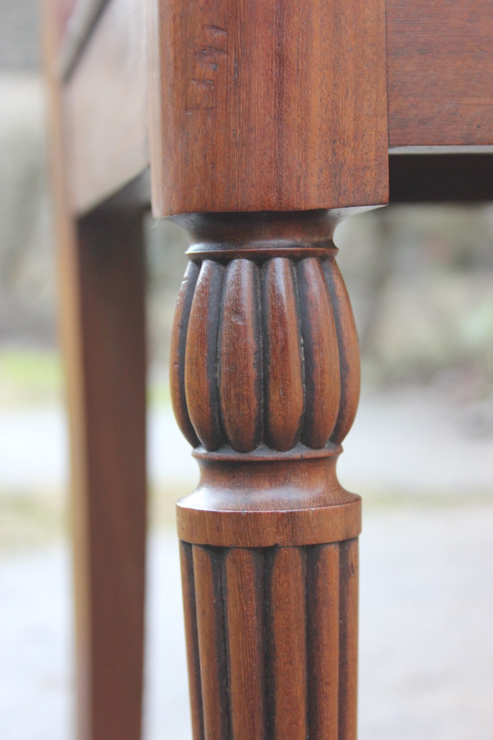 A pair of mahogany hall chairs featuring carved backrests with central circular mouldings, solid timber seats, and fluted turned front legs. View X