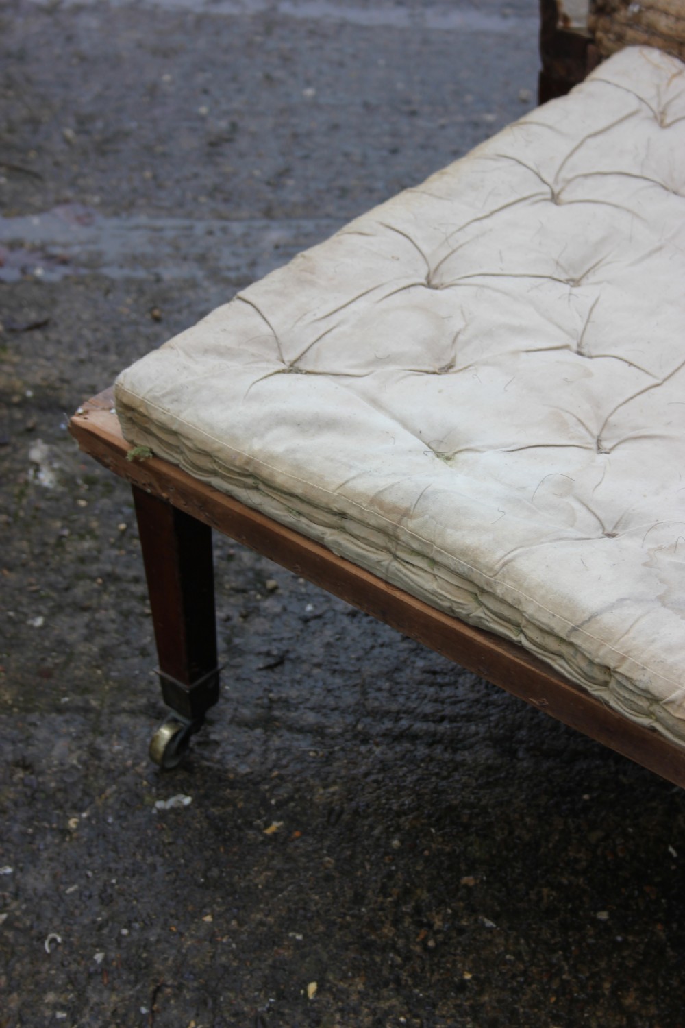An early 19th century wingback armchair frame lined in neutral calico, featuring square tapered mahogany legs with brass castors. View VI