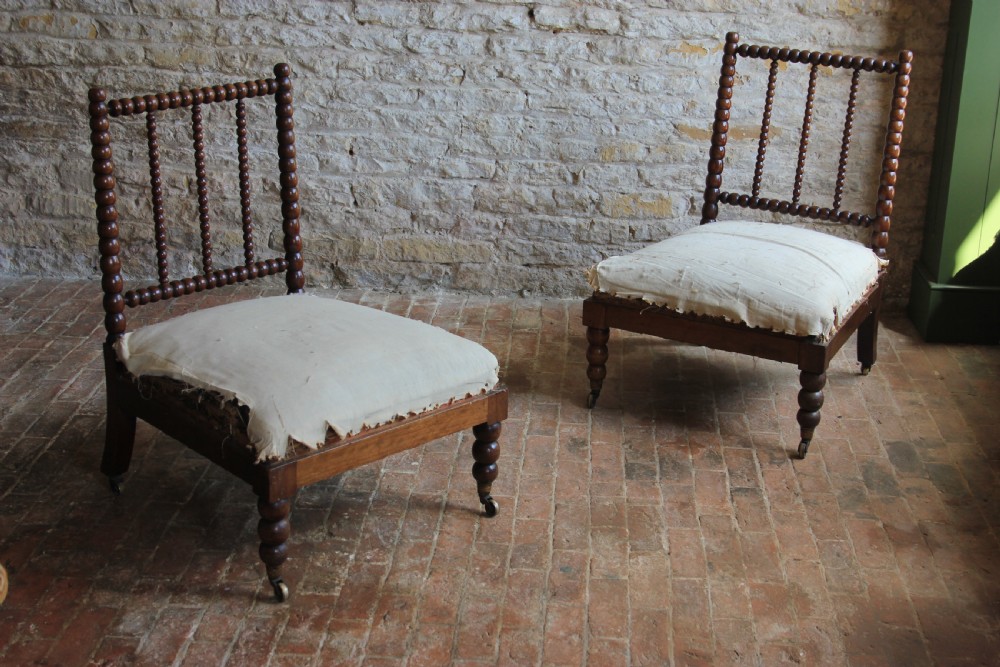 A pair of Victorian low-backed bobbin turned chairs with calico upholstered seats and brass castors.