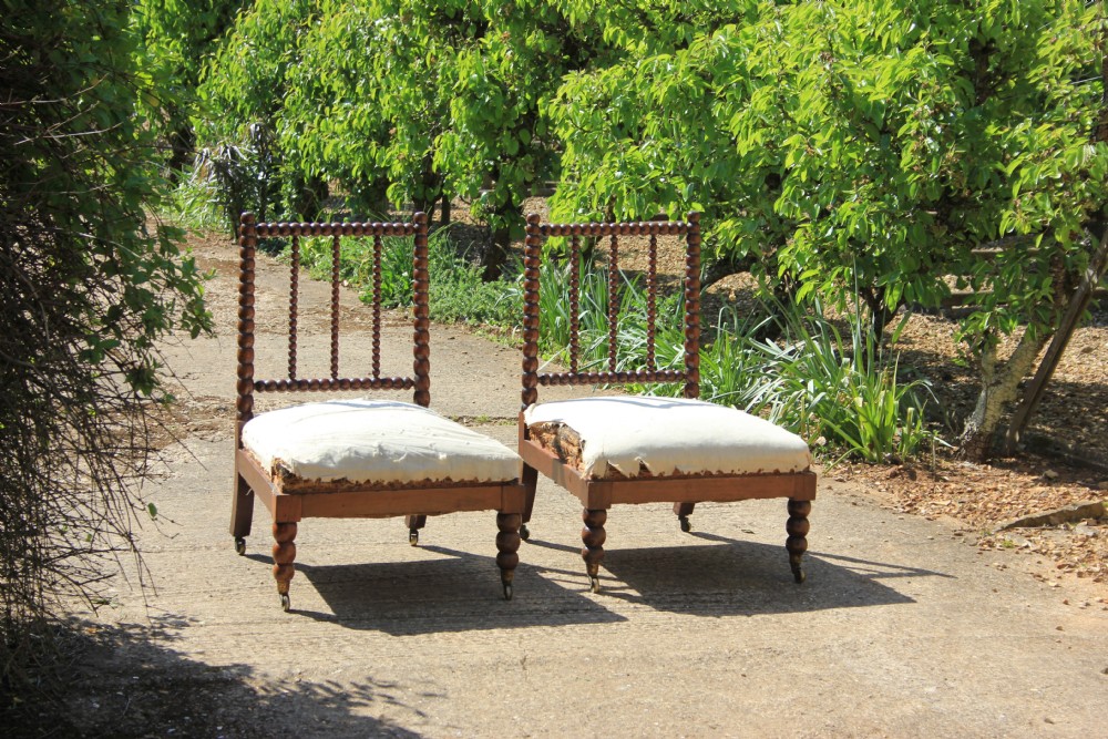 A pair of Victorian low-backed bobbin turned chairs with calico upholstered seats and brass castors. View II