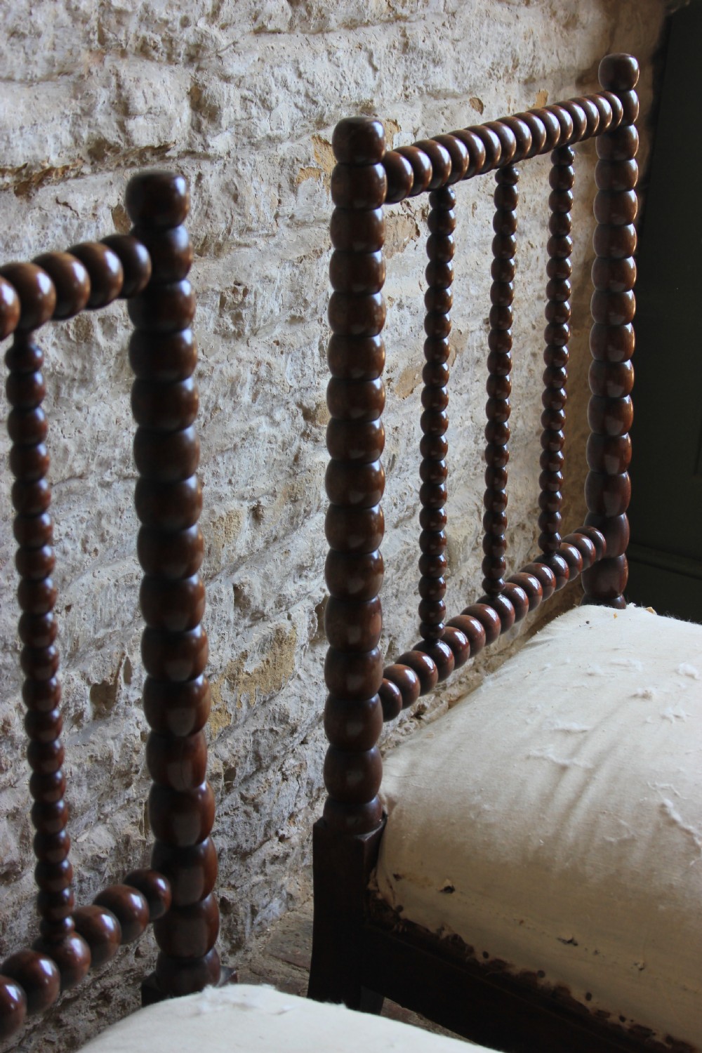 A pair of Victorian low-backed bobbin turned chairs with calico upholstered seats and brass castors. View IV