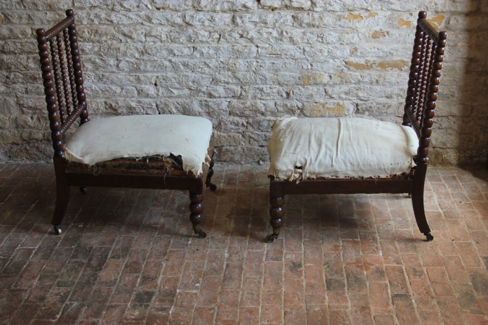 A pair of Victorian low-backed bobbin turned chairs with calico upholstered seats and brass castors. View V