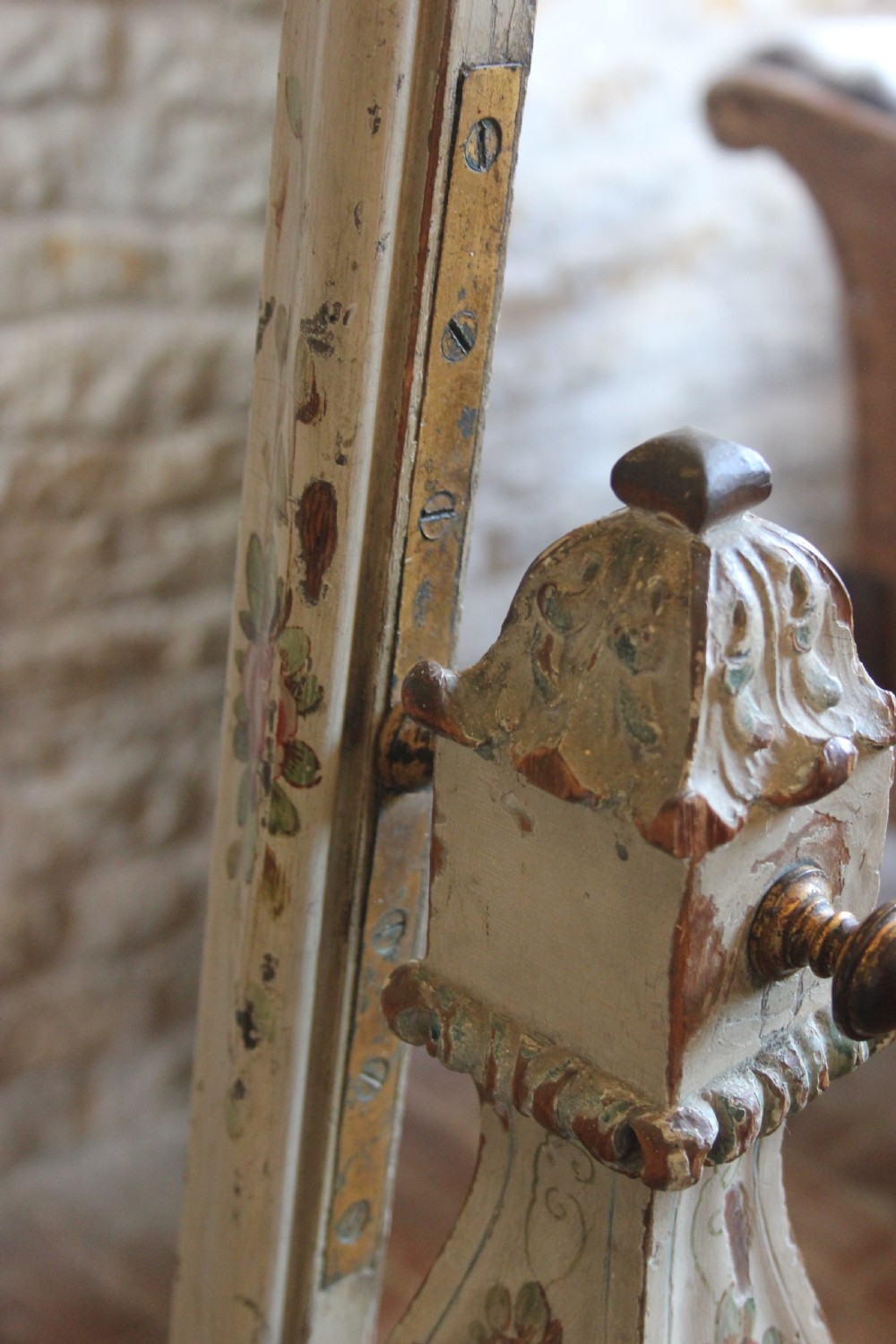 An antique 19th-century Italian cheval mirror featuring an off-white painted wooden frame decorated with hand-painted floral motifs and supported by carved trestle legs. View III