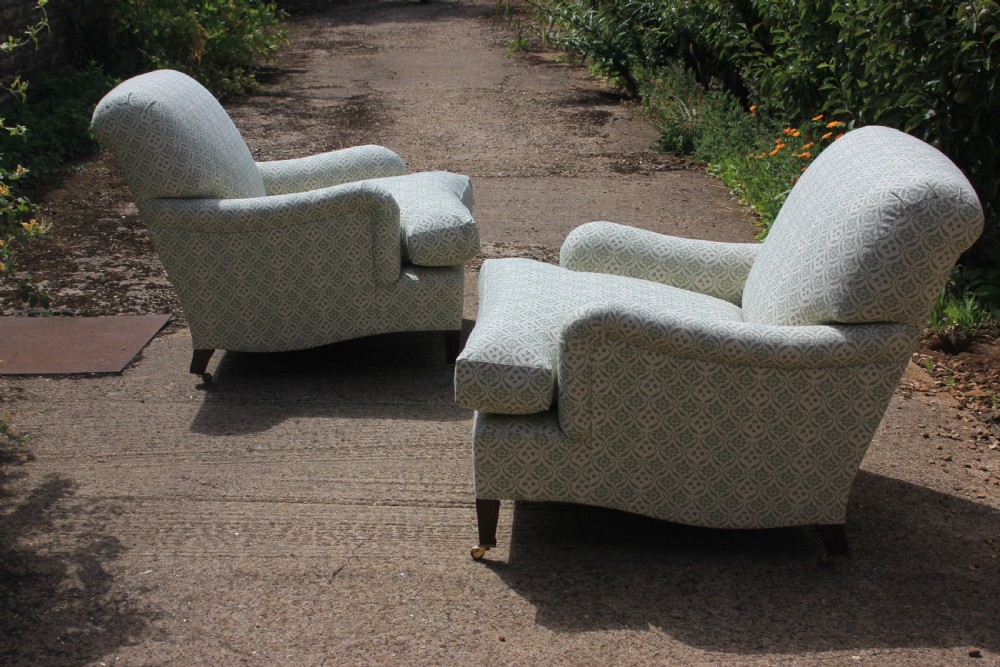 A pair of deep-seated armchairs upholstered in a sage green and off-white patterned fabric with turned front legs on brass castors. View IV