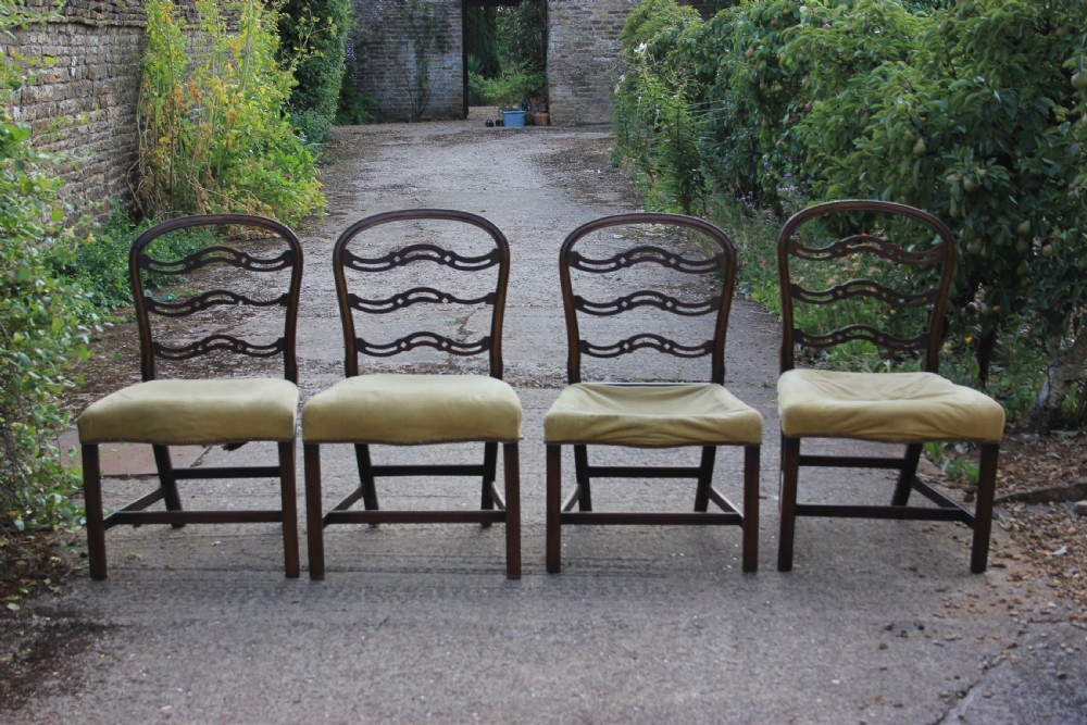 A Georgian dark mahogany dining chair featuring wave-pattern pierced horizontal back rails, a gold velvet upholstered seat with brass studding, and square legs joined by H-stretchers. View II