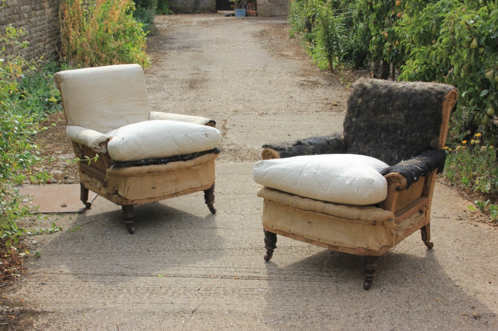 A pair of Victorian deep-seated armchairs in calico upholstery lining with turned timber legs and castors.