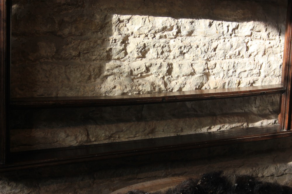 An 18th-century dark oak wall-mounted plate rack featuring a moulded cornice top and two horizontal shelf rails. View V