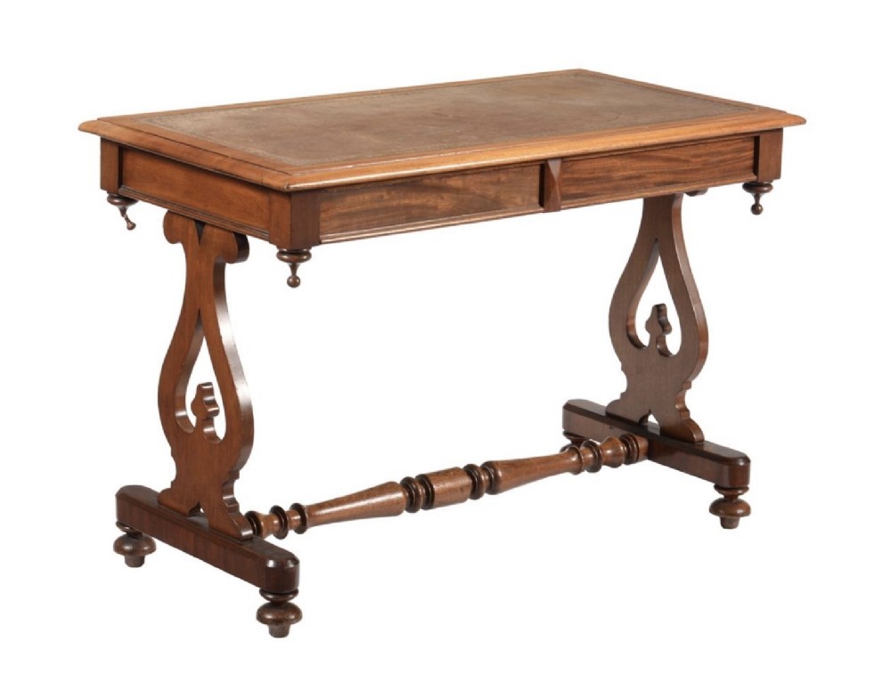 Victorian mahogany writing table featuring an inset leather surface, shaped side supports, turned stretcher, and drop finials.