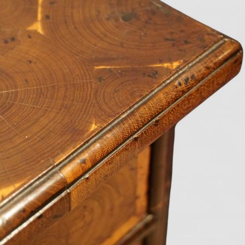 fig 2. A William and Mary period chest of drawers with oyster laburnum veneer, brass handles, and turned bun feet.