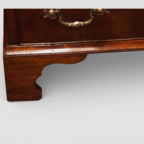 fig 2. A 19th-century small mahogany chest of drawers featuring four graduated drawers with brass swan-neck handles, a pull-out brushing slide, and bracket feet.