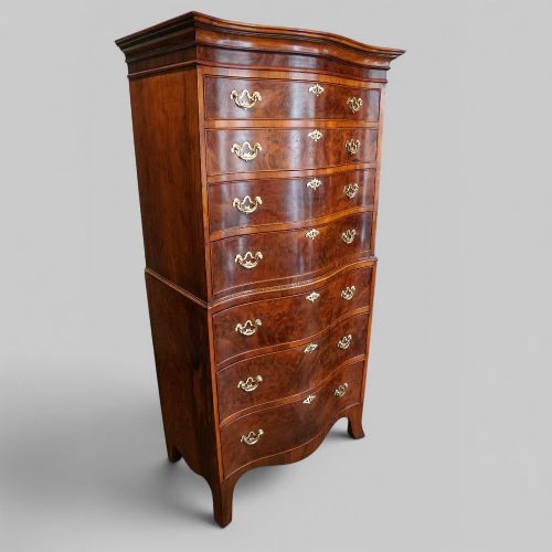 fig 1. A tall George V walnut serpentine front tallboy chest featuring multiple drawers with decorative brass drop handles.