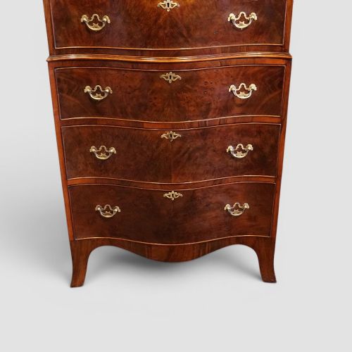 fig 2. A tall George V walnut serpentine front tallboy chest featuring multiple drawers with decorative brass drop handles.
