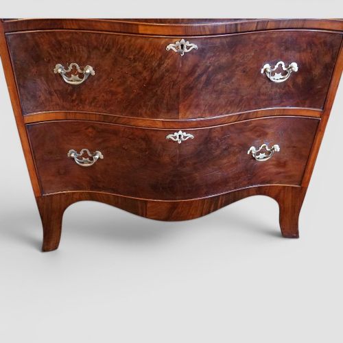 fig 4. A tall George V walnut serpentine front tallboy chest featuring multiple drawers with decorative brass drop handles.