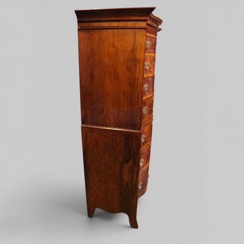 fig 5. A tall George V walnut serpentine front tallboy chest featuring multiple drawers with decorative brass drop handles.